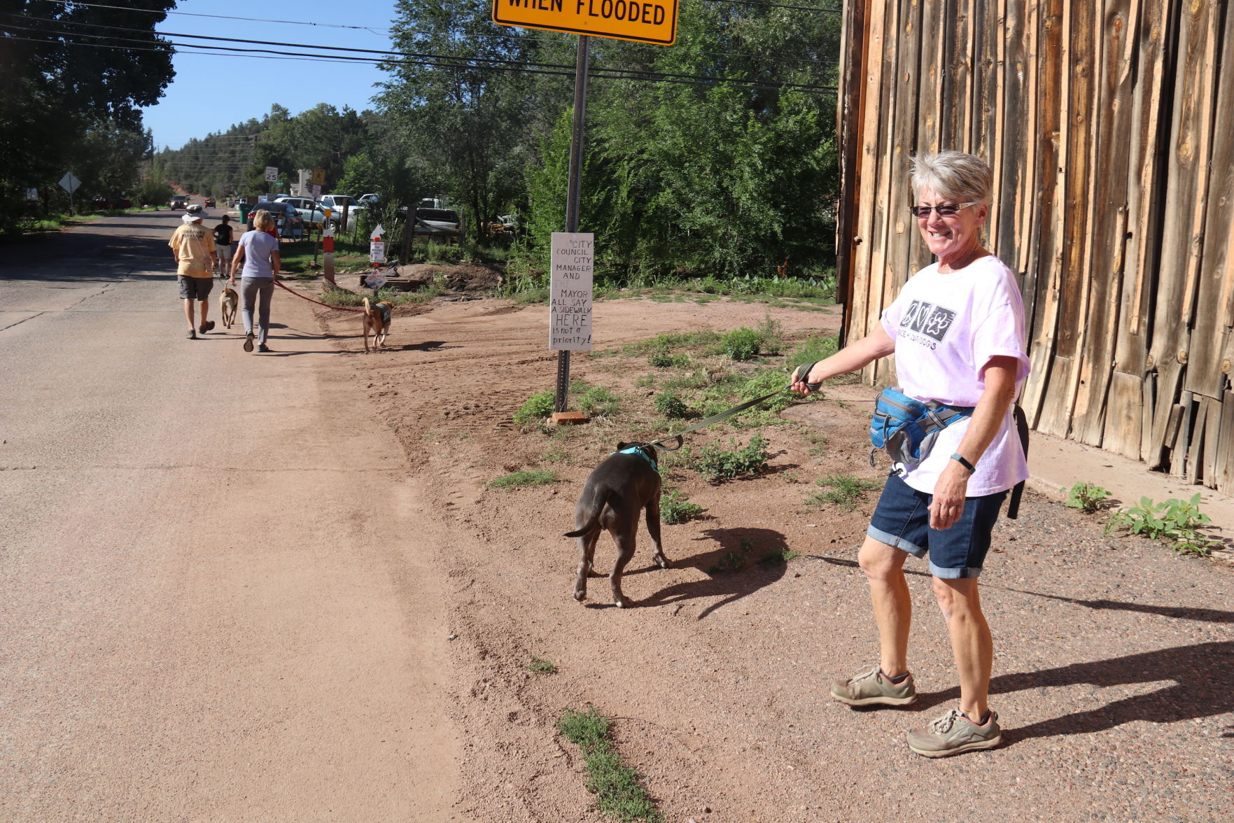 Teresa DuMarce and signs on McLane about sidewalks ladies who walk HSCAZ dogs